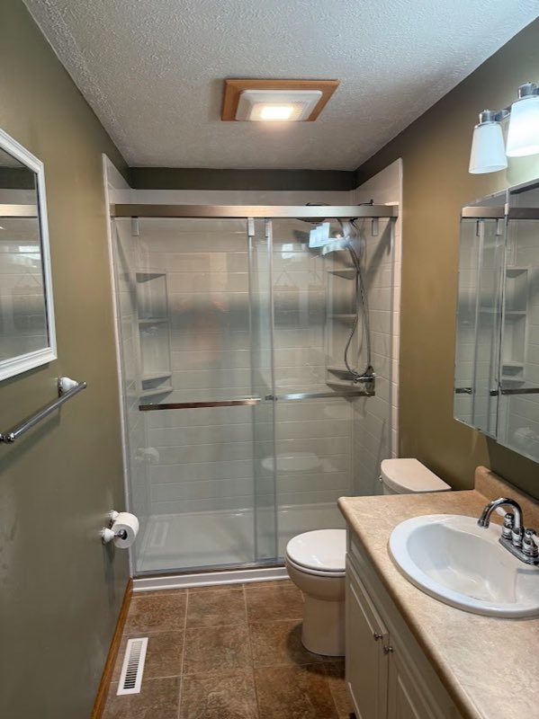 Finished bathroom remodel with a glass shower enclosure, vanity and new fixtures